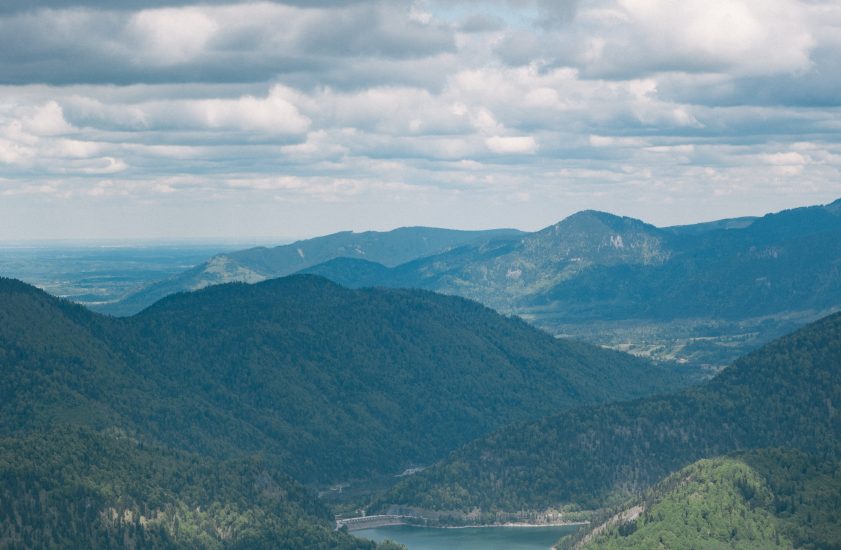 photo of lake surrounded by mountains